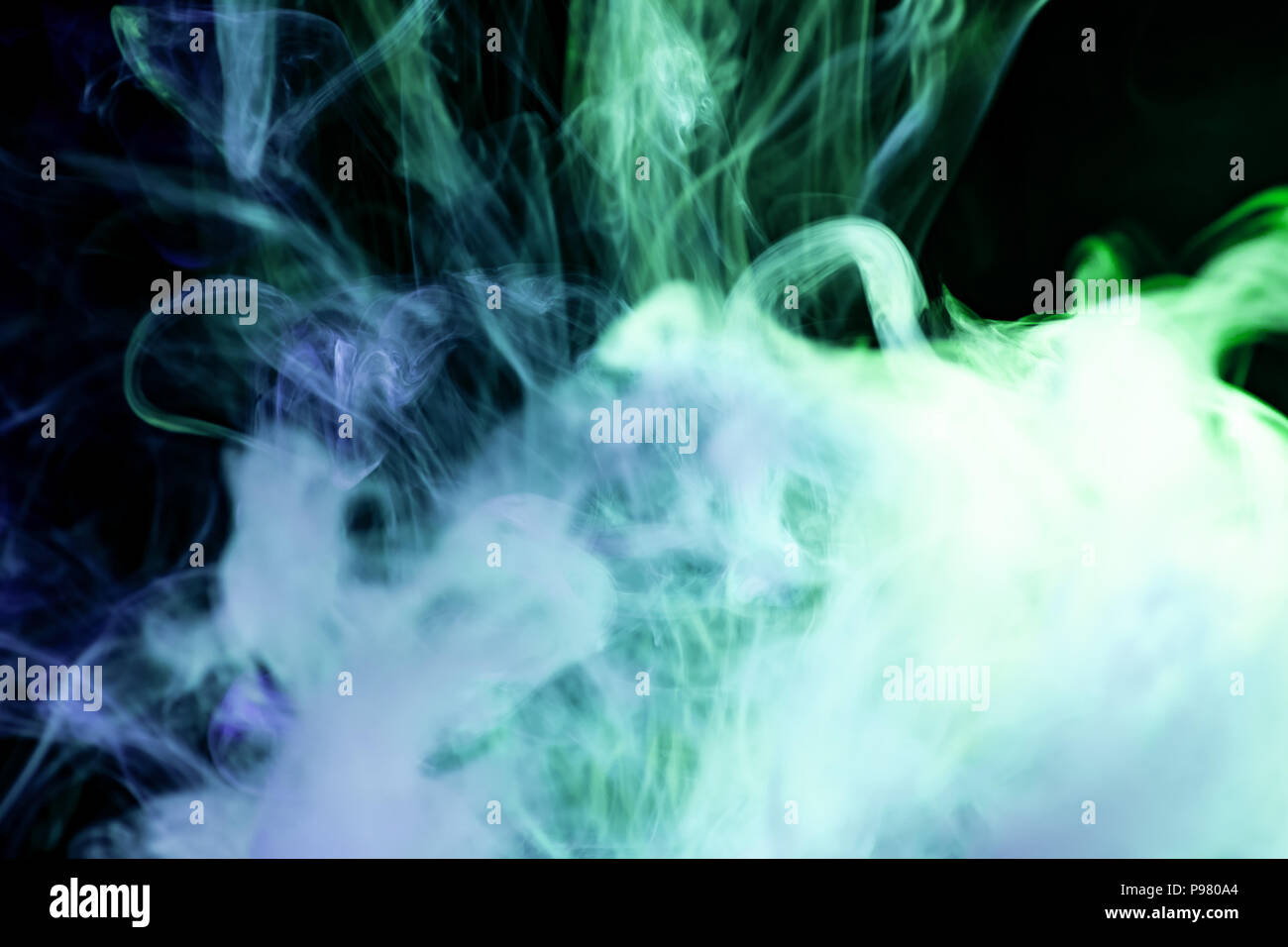 Blue and green cloud smoke on black isolated background Stock Photo - Alamy