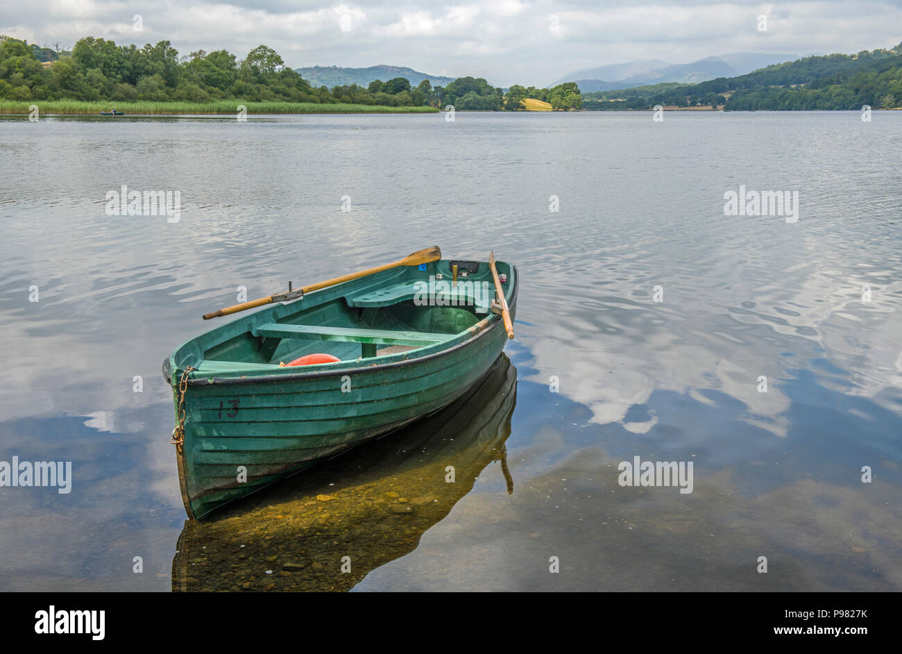 Esthwaite Water in the Lake District National Park with a green boat moored up. Stock Photo