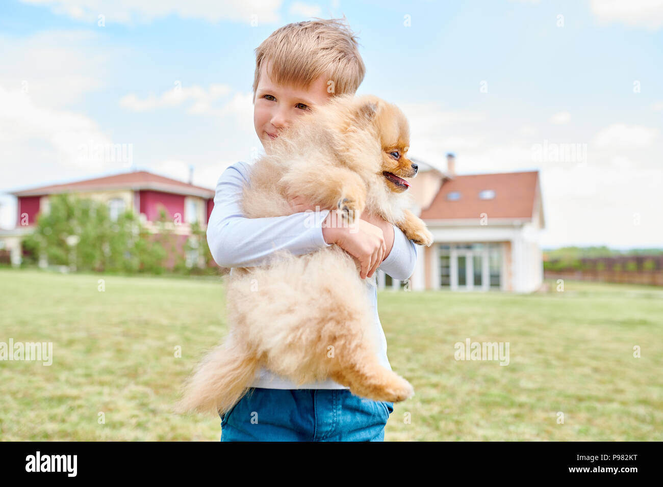 Little Boy Holding Pet Dog Stock Photo