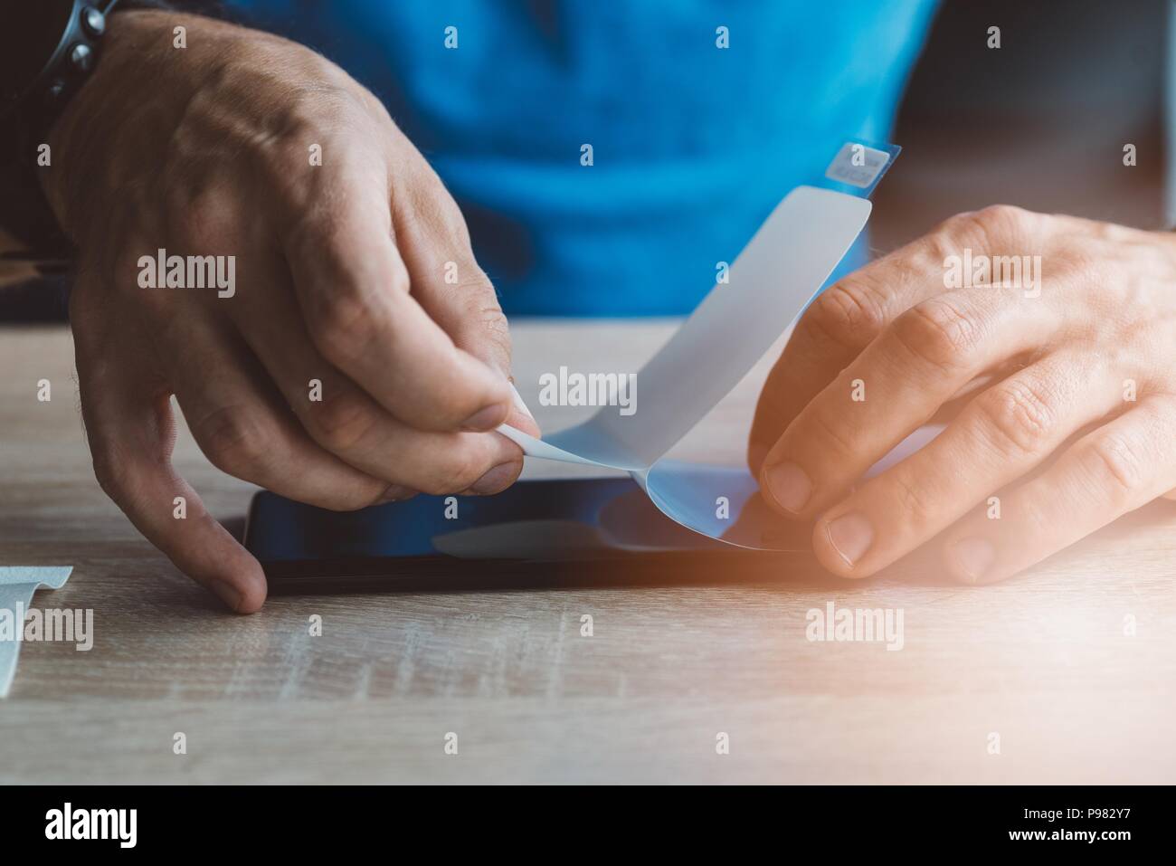Man applying protective screen foil on his smartphone touchscreen Stock Photo