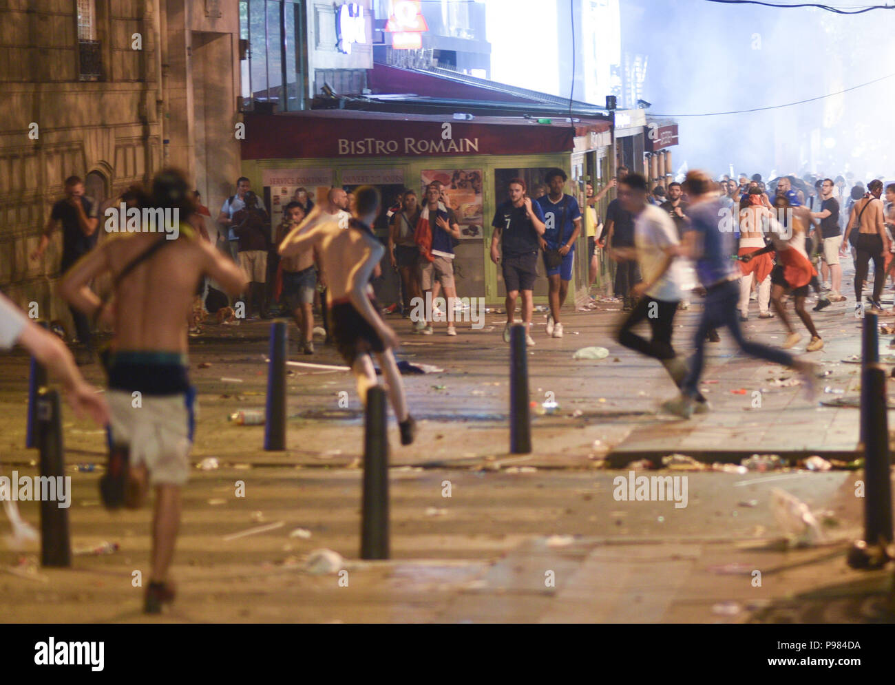 Paris, France. 15th July 2018.French supporters leave the Champs-Elysees avenue after riot police fired tear gas to disperse groups of violent youths. France won the World Cup by beating Croatia 4-2 in the final. Des supporters quittent les Champs-Elysees apres que la police ait utilise des gaz lacrymogenes afin de disperser des groupes violents, suite a la victoire de la France en Coupe du Monde. *** FRANCE OUT / NO SALES TO FRENCH MEDIA *** Credit: Idealink Photography/Alamy Live News Stock Photo