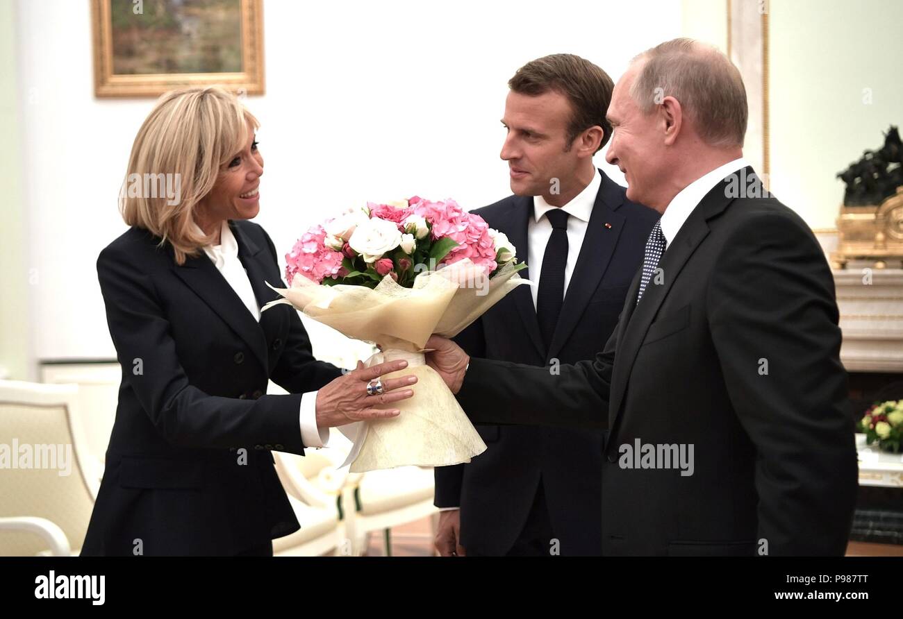 Moscow, Russia. 15th July 2018. Russian President Vladimir Putin, right, presents Brigitte Macron with flowers prior to meeting with her husband French President Emmanuel Macron, center, at the Kremlin July 15, 2018 in Moscow, Russia. Macron was in Moscow to attend the final match in the Soccer World Cup which France won 4-2 over Croatia. Credit: Planetpix/Alamy Live News Stock Photo