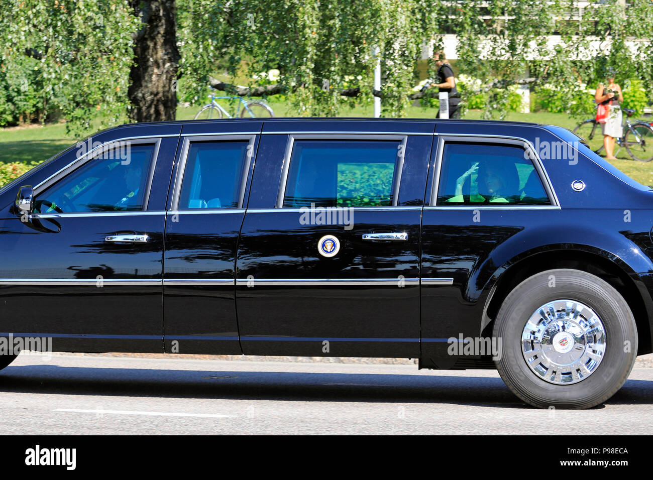 Helsinki, Finland. July 16, 2018. The motorcade of US President Donald Trump and First Lady Melania Trump passes along Ramsaynranta ahead of US and Russian Presidents' historic meeting. First Lady Melania Trump waves to the crowd; President Trump shows partly in profile. Credit: Taina Sohlman/Alamy Live News Stock Photo