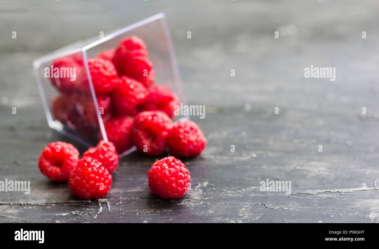 Fresh raspberries scattered on the wooden table Stock Photo