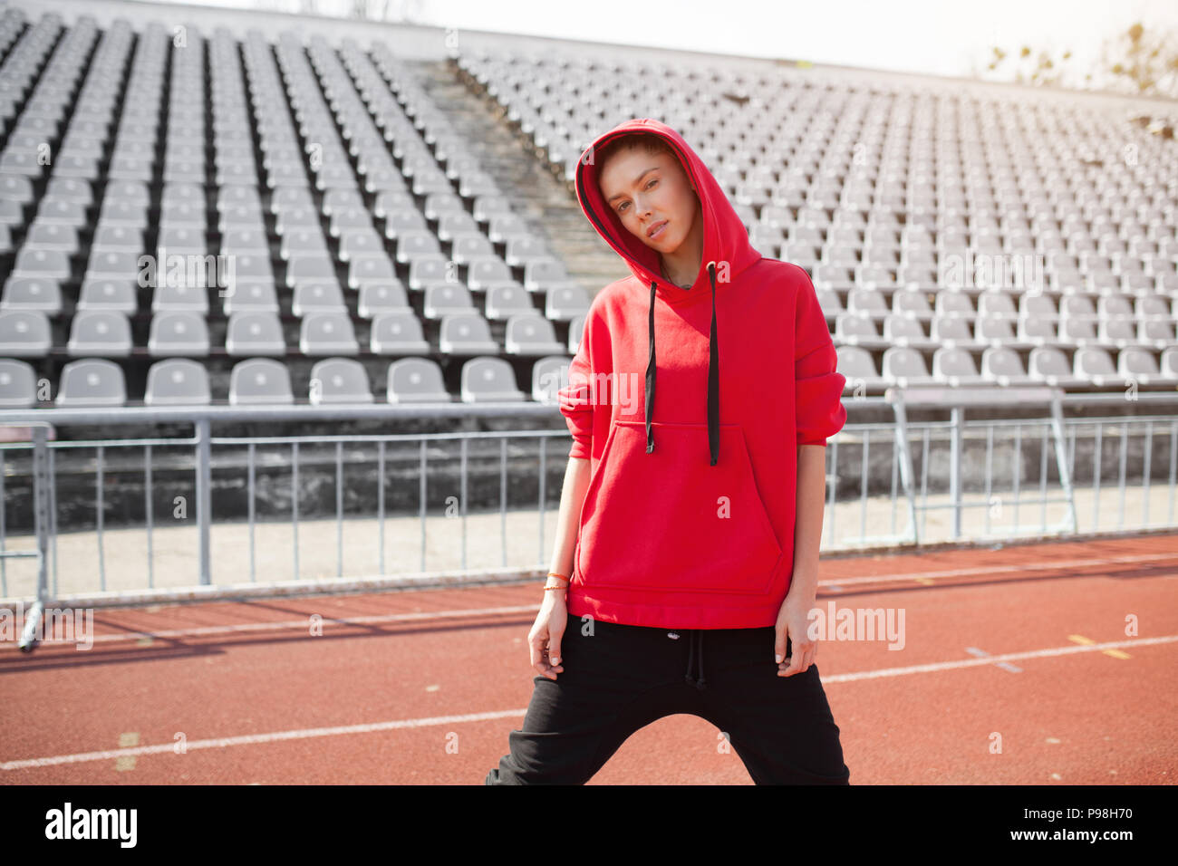 A Beautiful Young Girl Of Mixed Race Stands On A Sports Stadium Running Track Dressed In A Red Hoodie With A Hood Sportswear For Training In The Fall Stock Photo Alamy