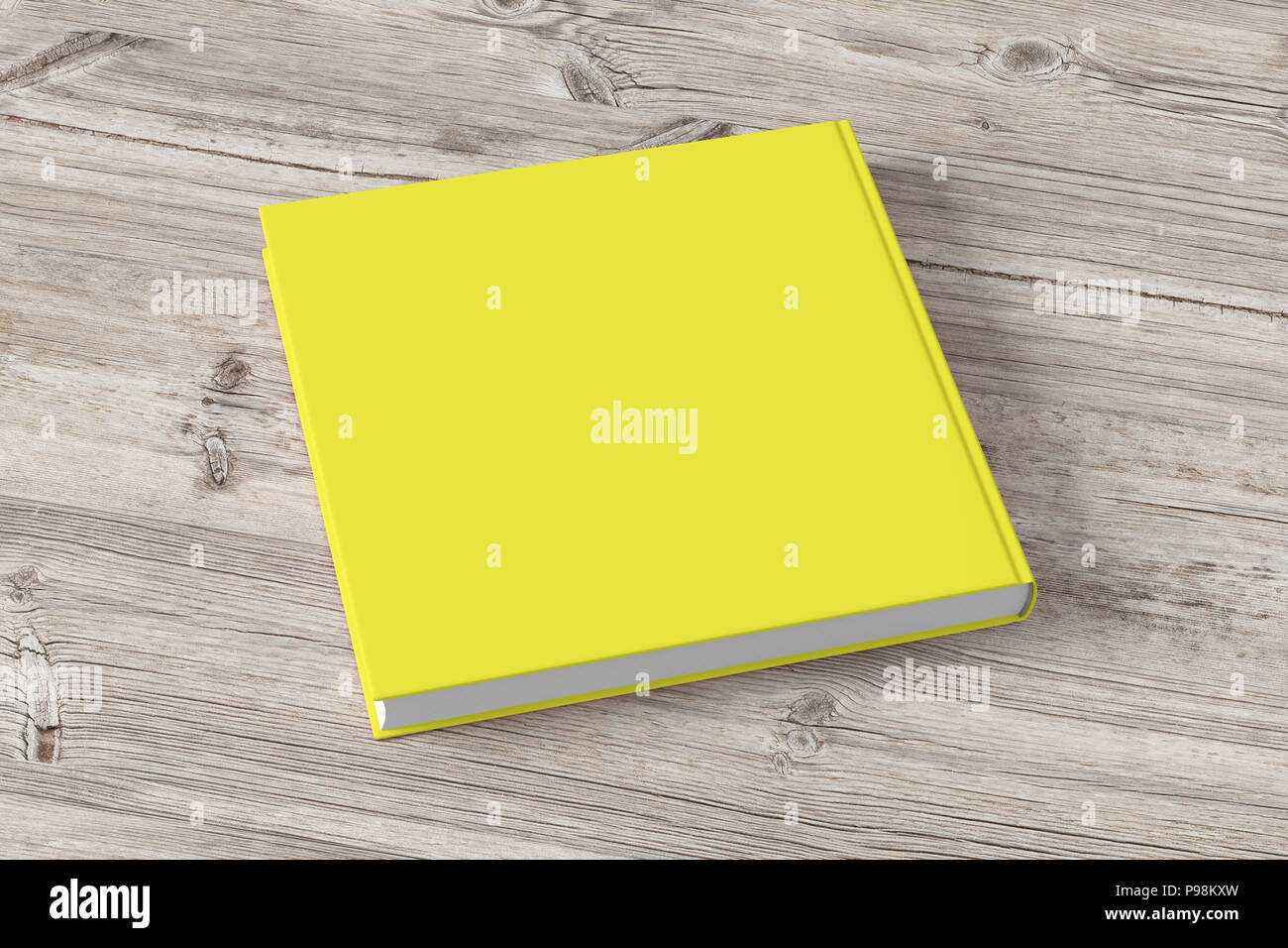 Blank yellow book cover on wooden background. Isolated with clipping