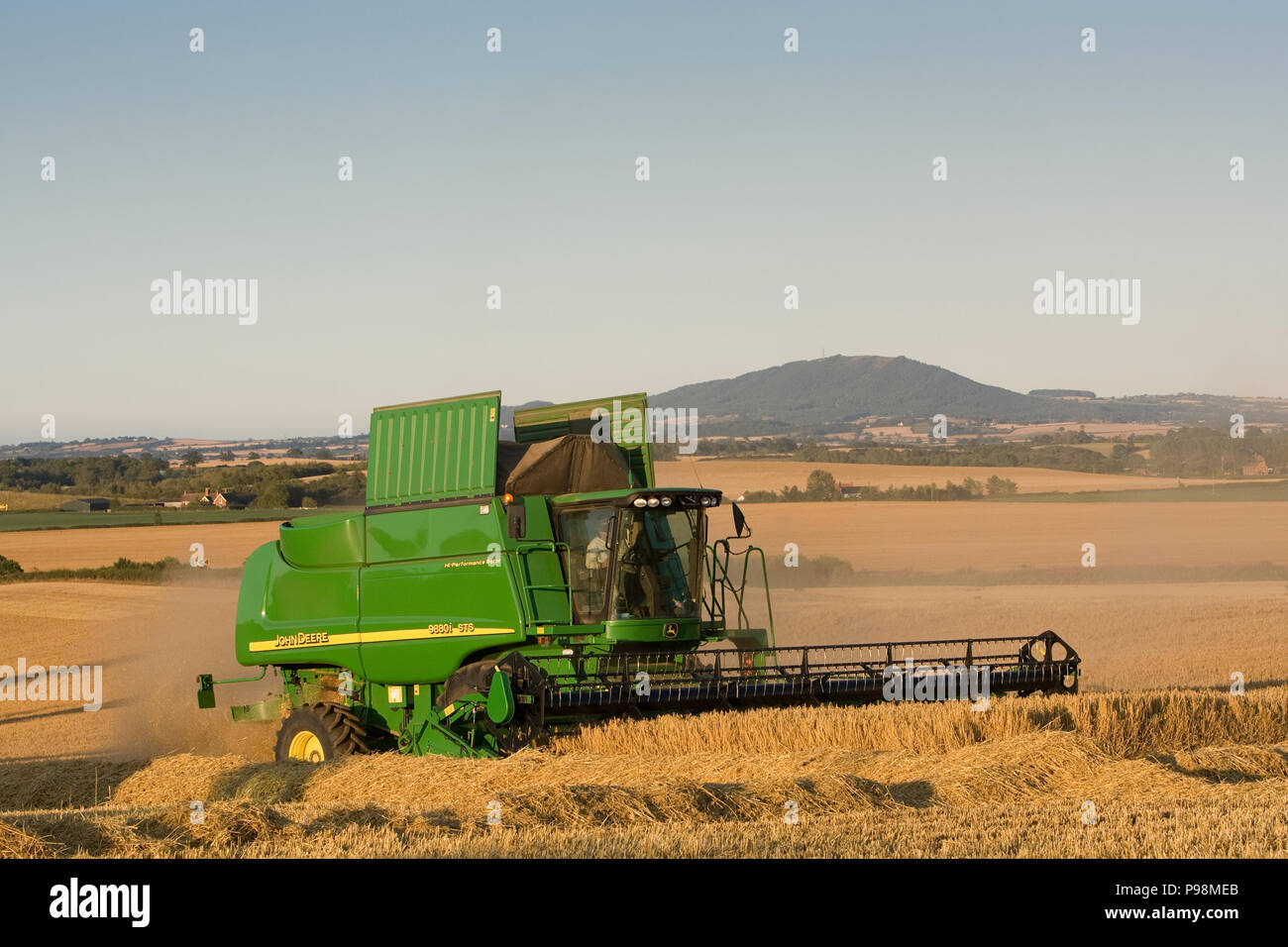 Close up of green combine harvester at work on a summer evening in the wheat fields in Shropshire, 2011. Stock Photo