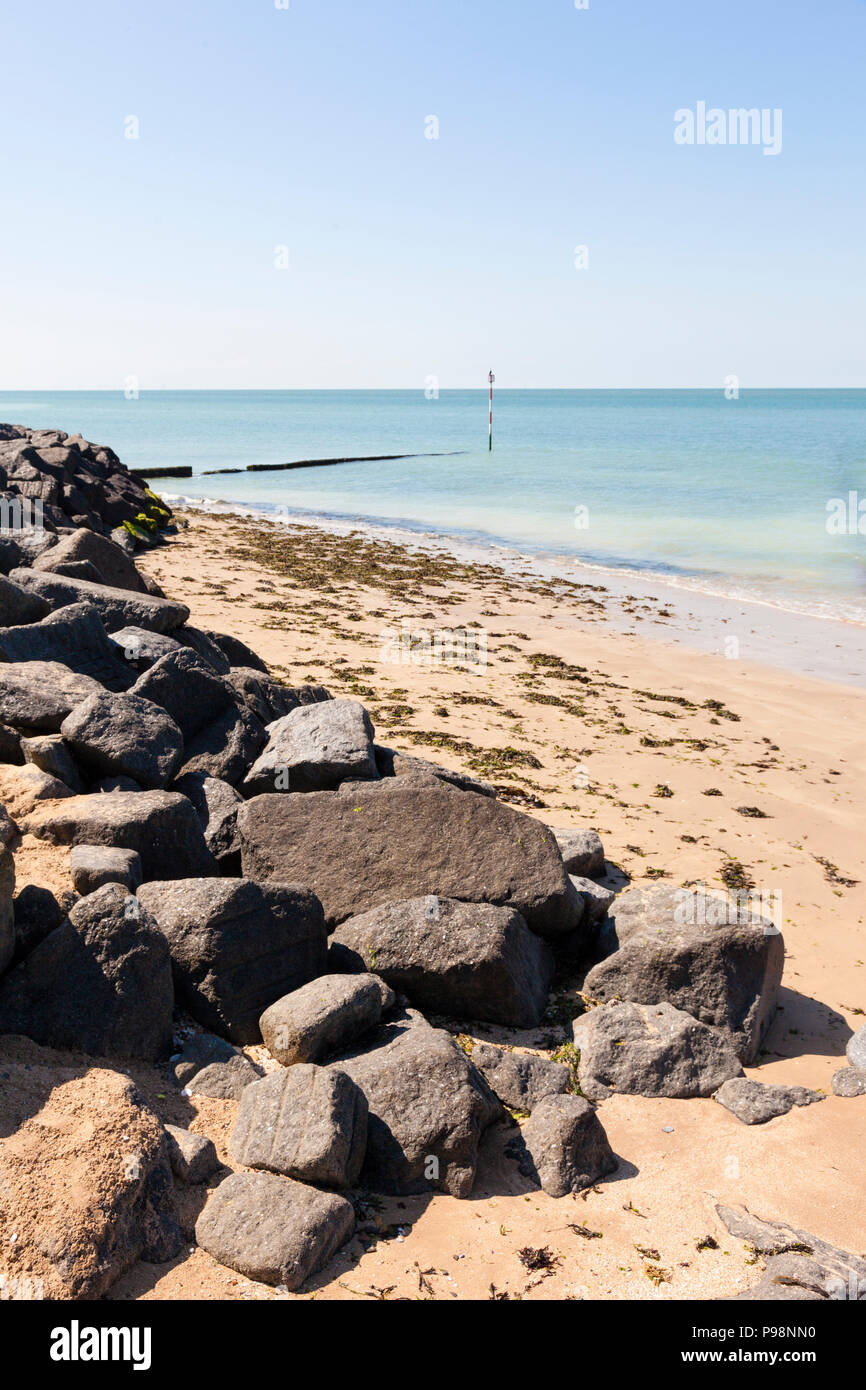 Artificial granite block sea defences above a sandy sedimentary beach, Margate, Kent, UK Stock Photo