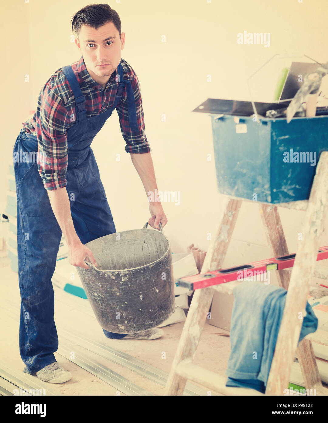 Worker repairing room and looking for necessary tool Stock Photo