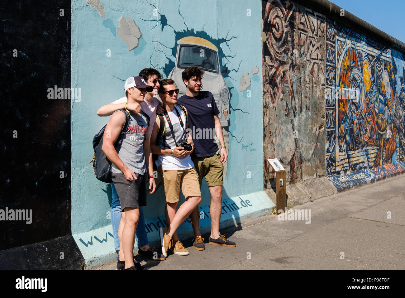 Berlin, Germany - july 2018: Group of young men taking group picture at  Berlin Wall / East Side Gallery in Berlin Stock Photo