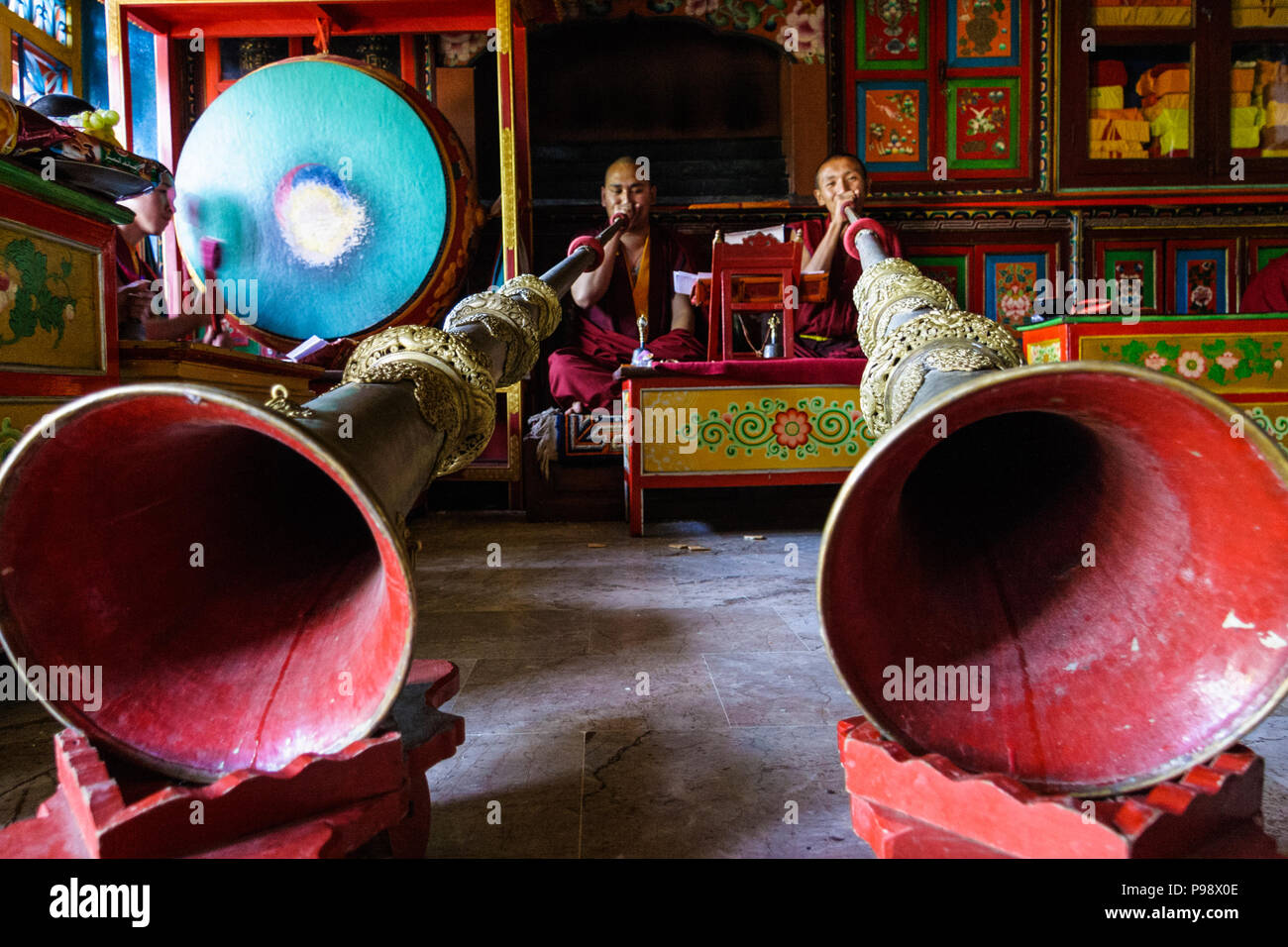 Two Tibetan monks playing horns at a lamasery in Bodhnath, Kathmandu, Nepal Stock Photo