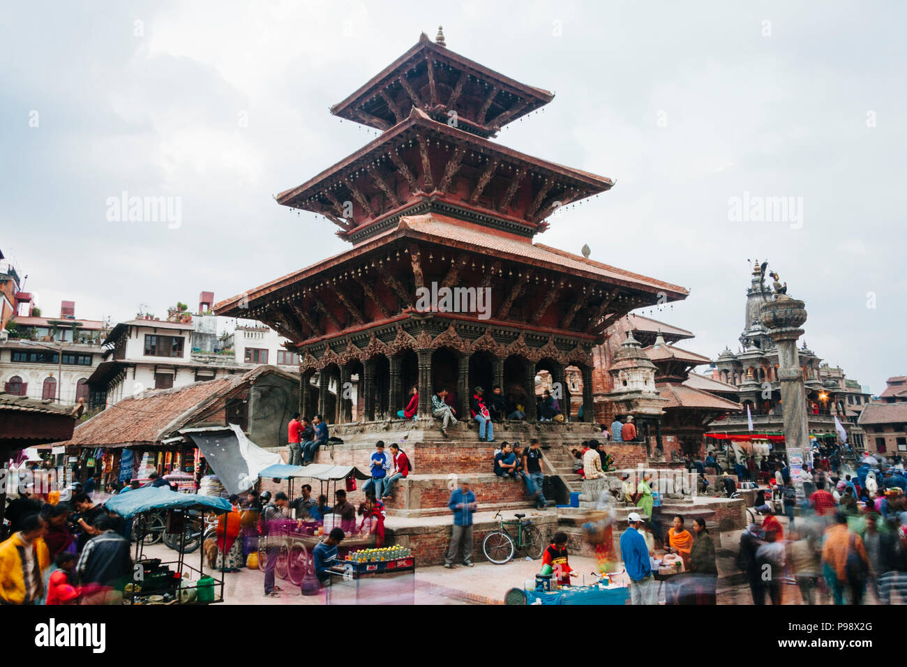 Lalitpur, Kathmandu Valley, Nepal : People walk past the Bhimsen temple (1680) at the Unesco listed Patan Durbar square. Stock Photo
