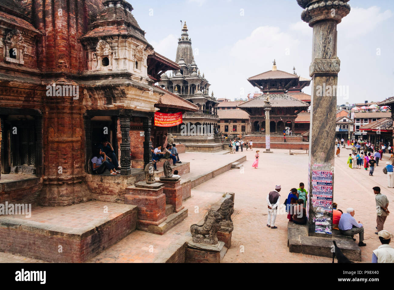 Lalitpur, Kathmandu Valley, Nepal : Passersby at the Unesco listed Patan Durbar square. Krishna mandir in background. Stock Photo