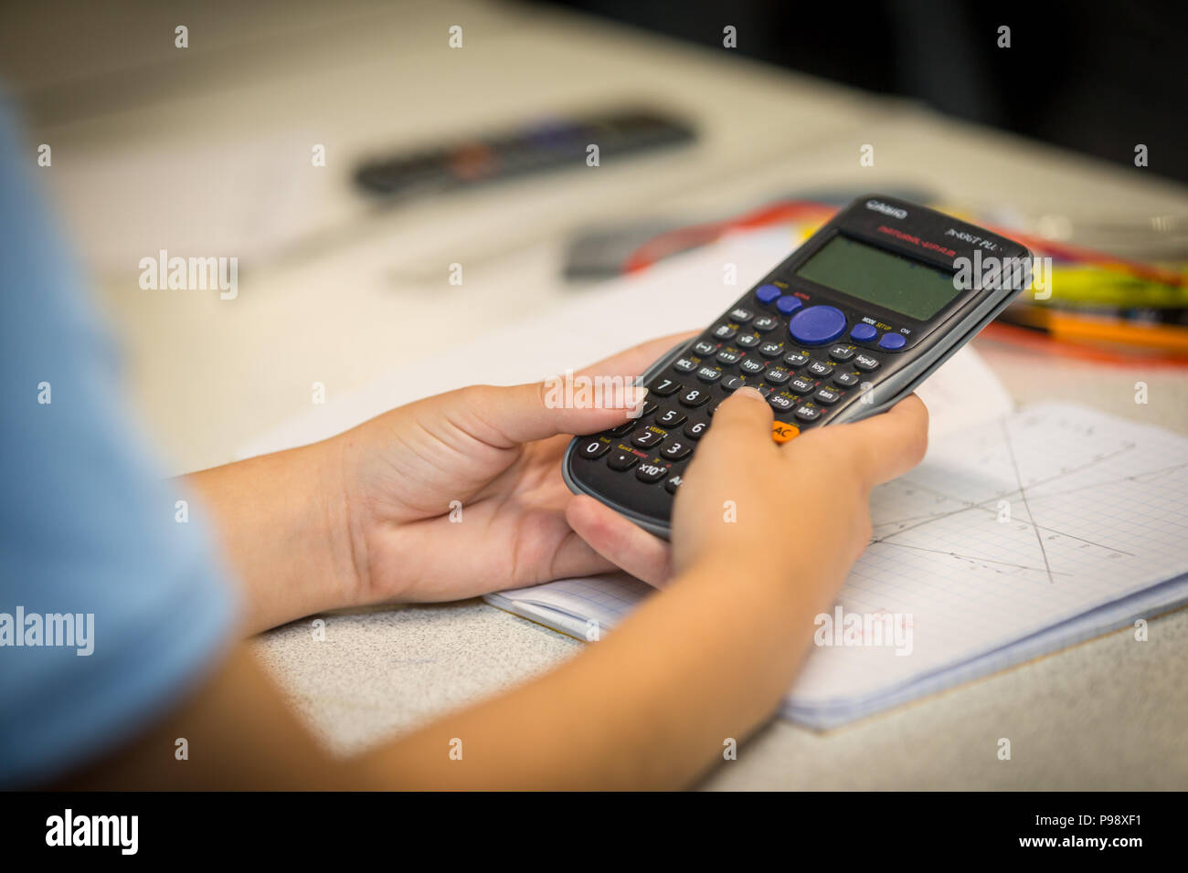 Secondary aged school pupil using an electronic calculator in a math lesson uk Stock Photo