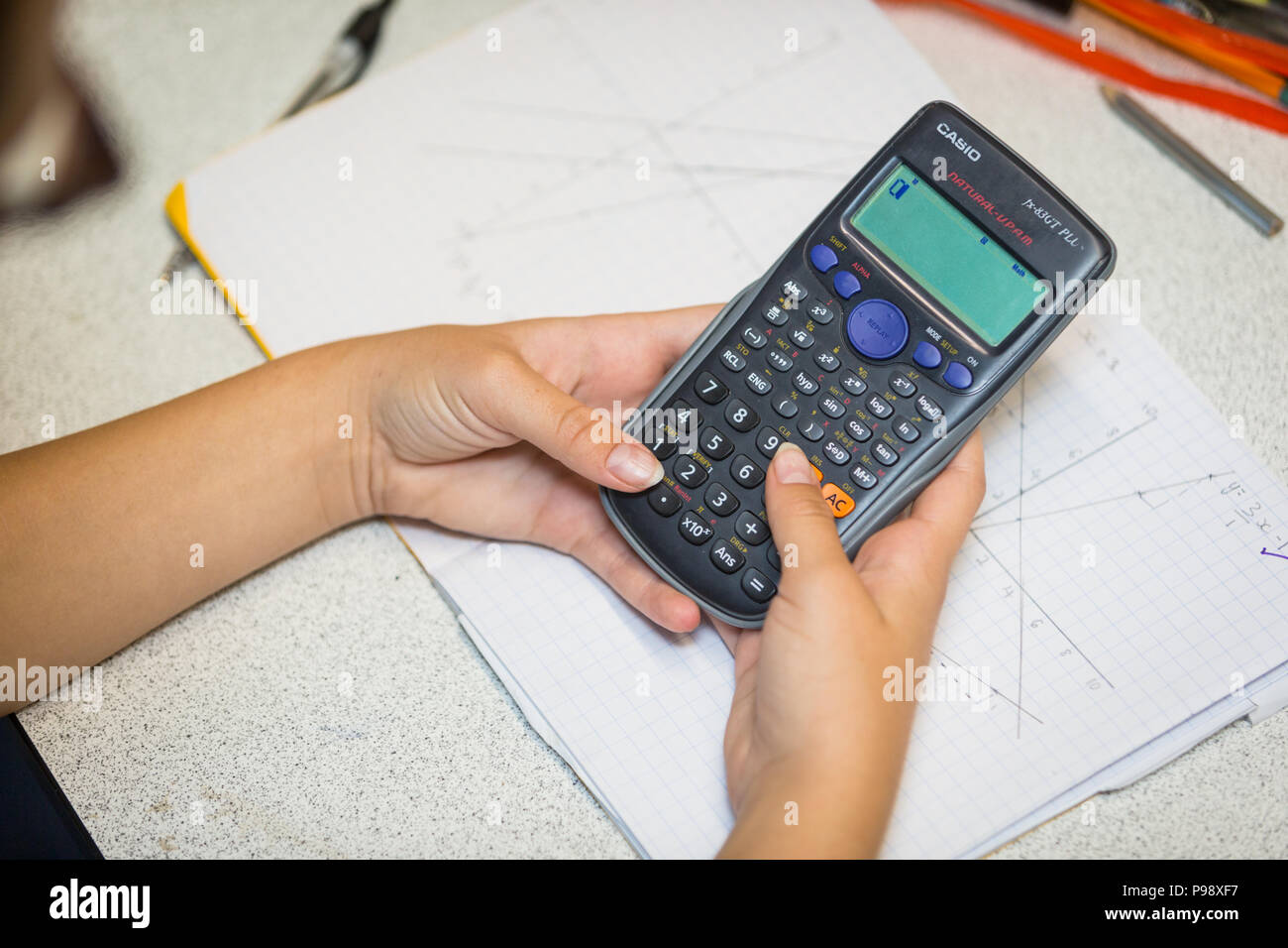 Secondary aged school pupil using an electronic calculator in a math lesson uk Stock Photo
