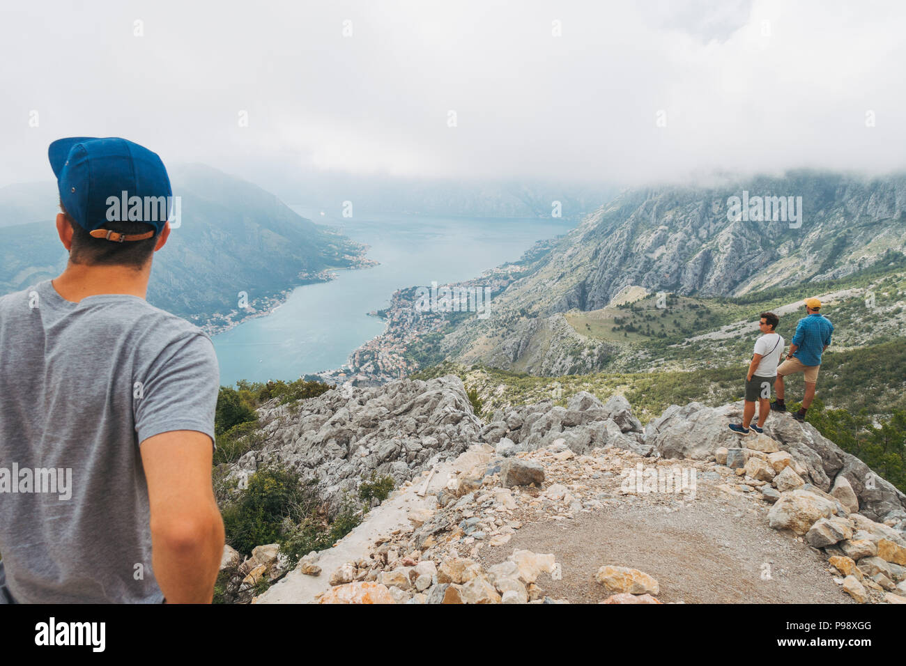 Young male tourists look out into the inlet above Kotor, Montenegro Stock Photo