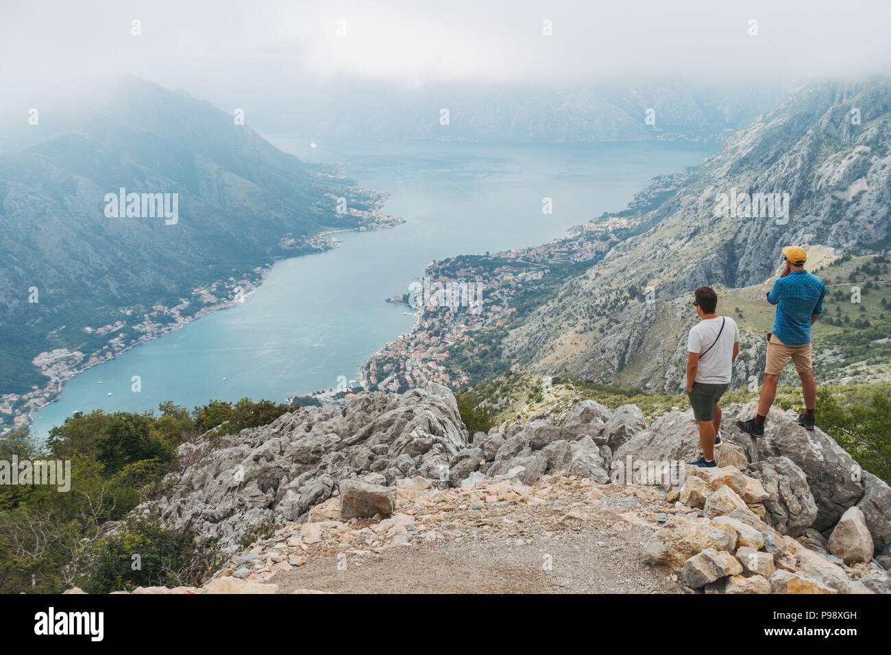 Young male tourists look out into the inlet above Kotor, Montenegro Stock Photo