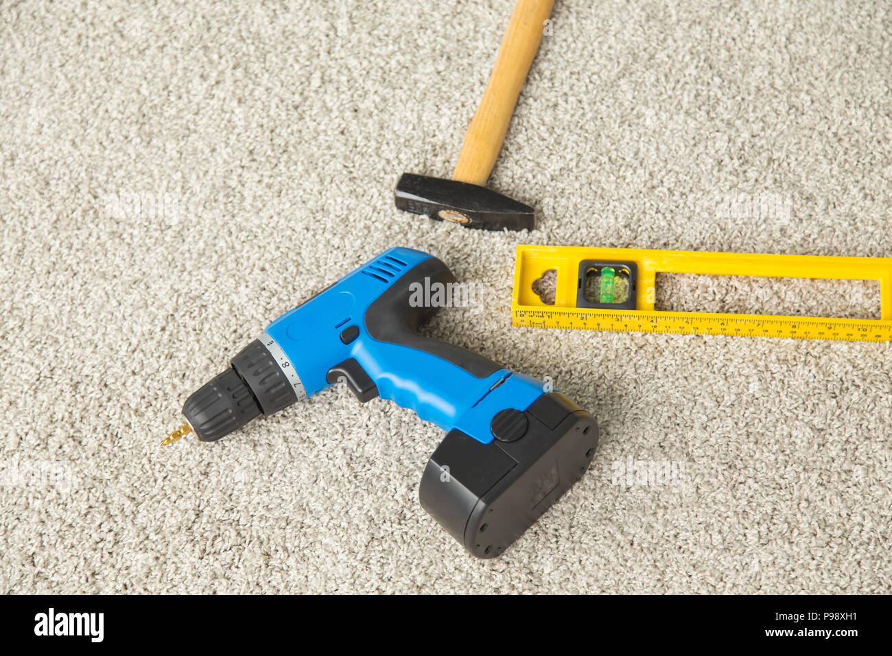 Hammer, drill and builders level on the floor Stock Photo Alamy
