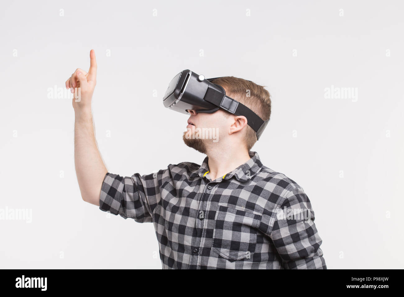 Man wearing virtual reality glasses raising his hand Stock Photo - Alamy