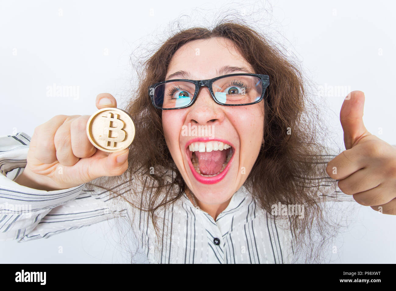 Funny woman holding golden bitcoin and showing thumbs up successful