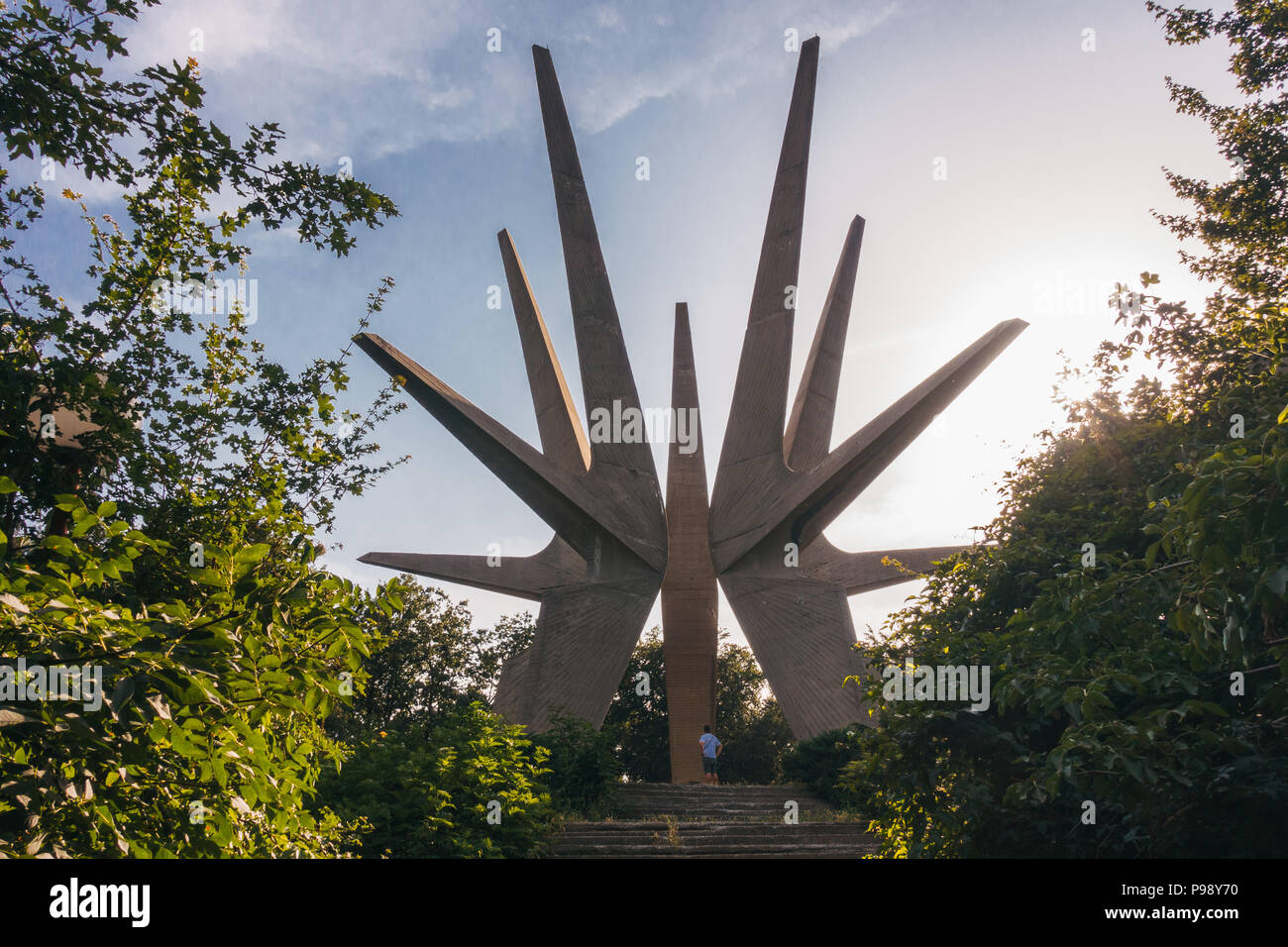 A tourist is dwarfed by the Kosmaj Memorial Complex, a pointy star-like monument erected to the south of Belgrade, Serbia Stock Photo