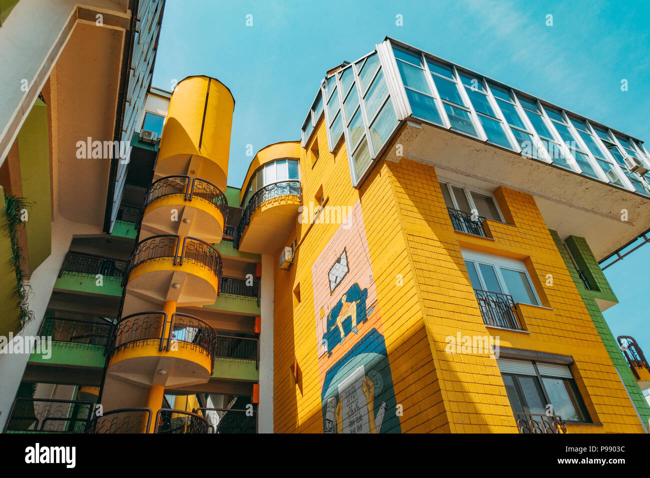 The Papagajka (Parrot) building in Sarajevo, with shades of the brutalist architecture of socialist Yugoslavia, now painted bright yellow and green. Stock Photo