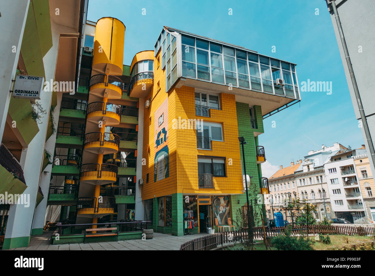 The Papagajka (Parrot) building in Sarajevo, with shades of the brutalist architecture of socialist Yugoslavia, now painted bright yellow and green. Stock Photo