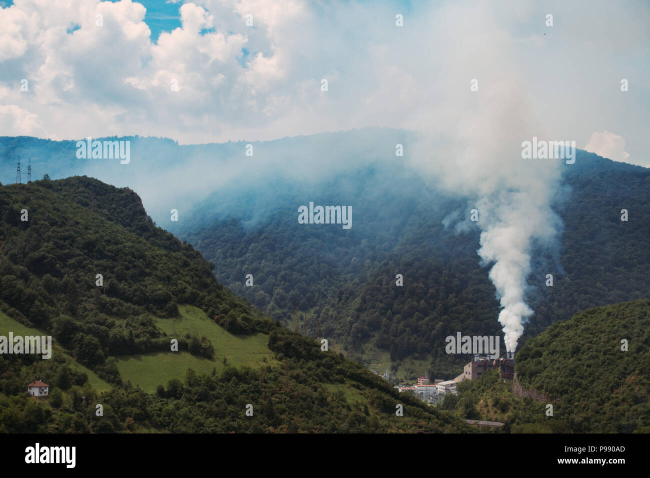 a metal smelter billows smoke into the calm summer air in Jajce, Bosnia and Herzegovina Stock Photo