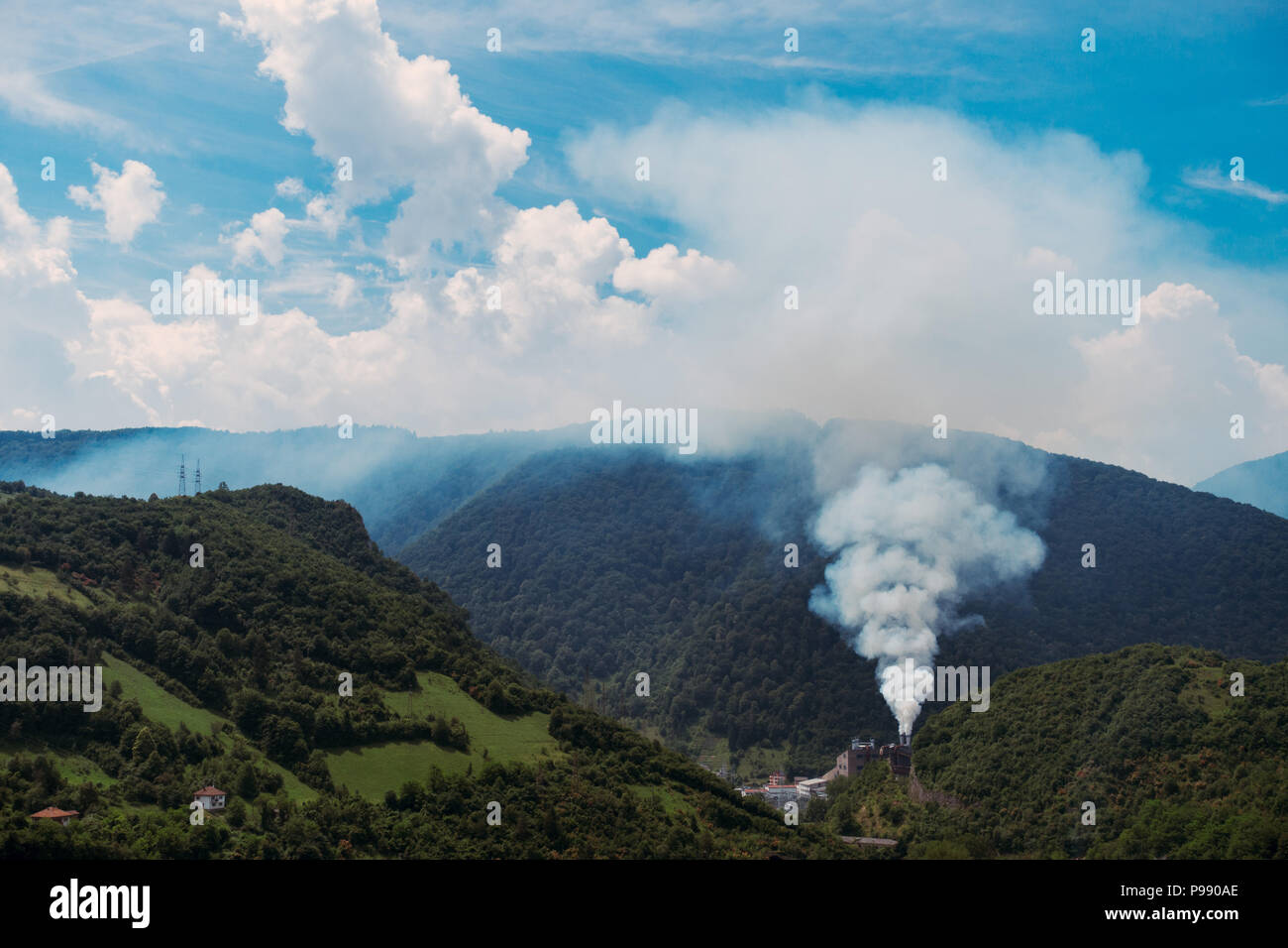 a metal smelter billows smoke into the calm summer air in Jajce, Bosnia and Herzegovina Stock Photo