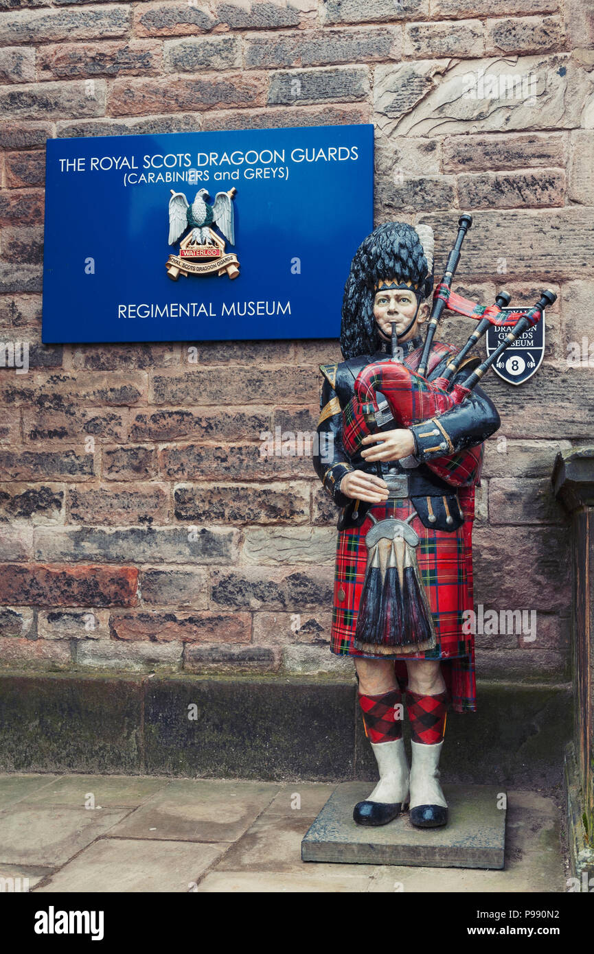 Statue of Scottish piper playing bagpipe at entrance of Regimental