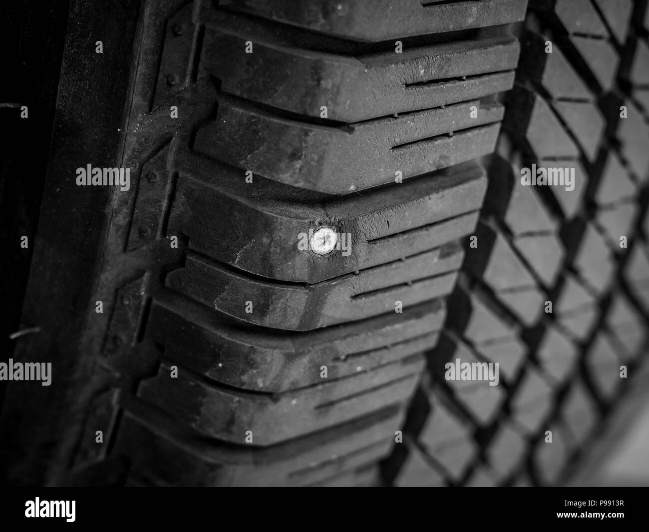 Closeup of rubber tires leak, The metal nail puncturing the tire Stock