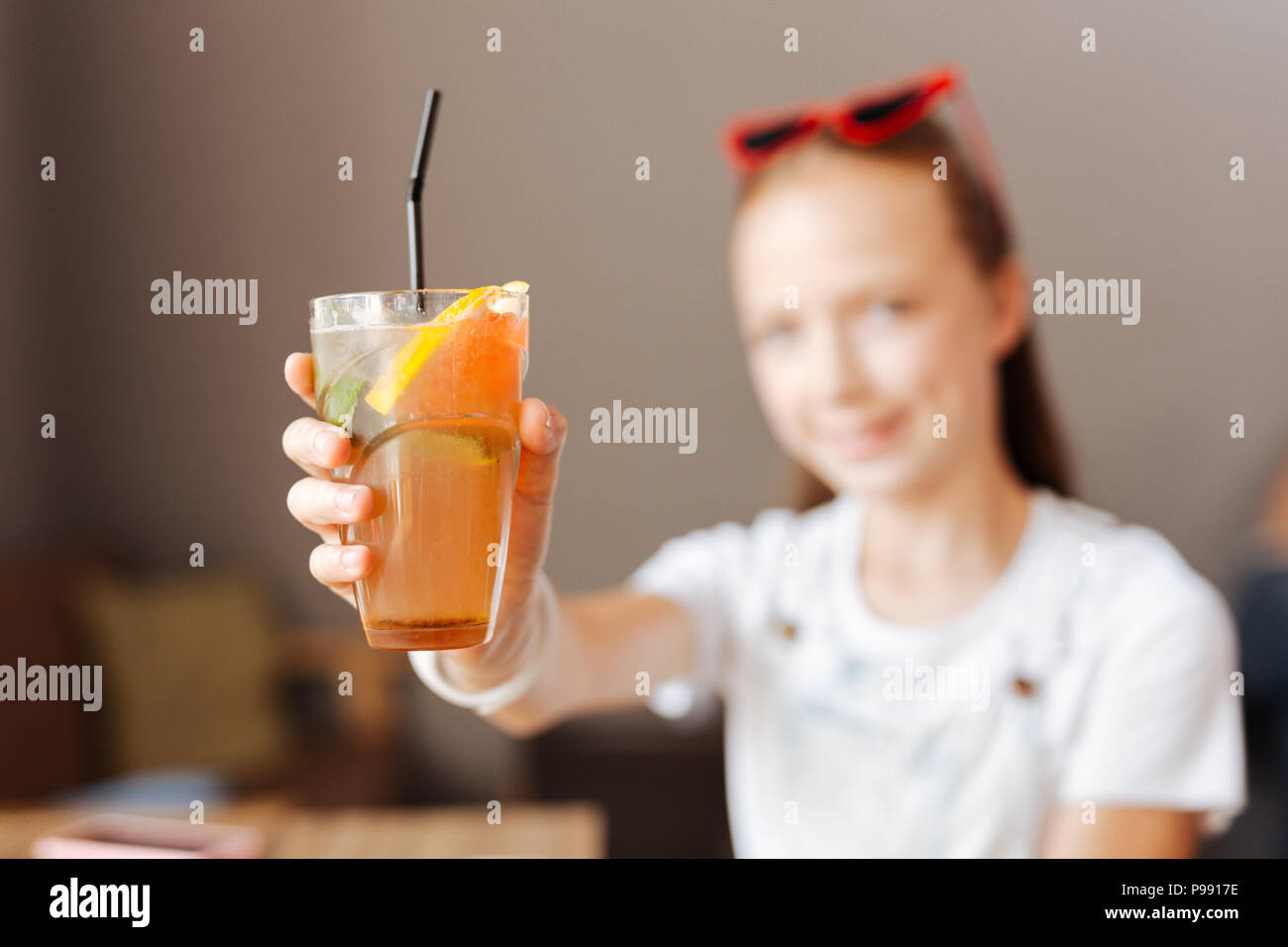 Modern teenager holding refreshing cocktail in her hands Stock Photo