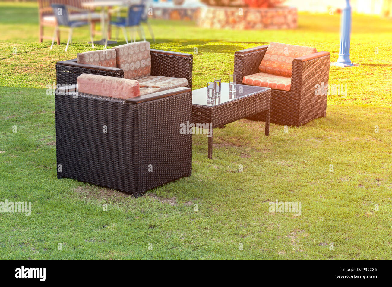 Chair with table in the cozy home garden with green grass lawn Stock