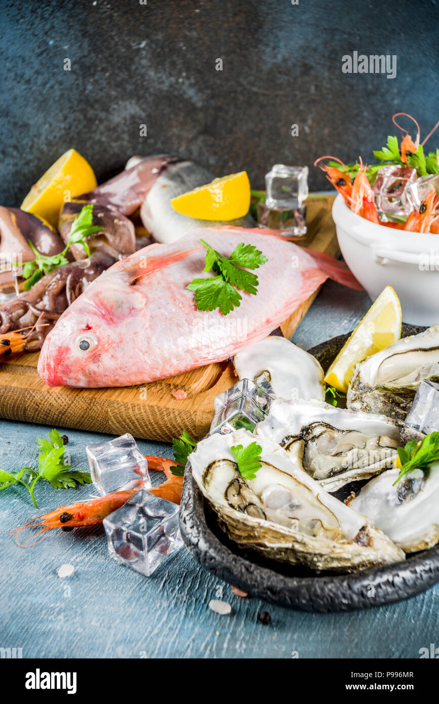 Fresh raw seafood squid shrimp oyster mussels fish with spices of herbs