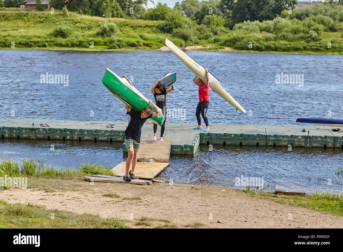Polotsk, Belarus - July 6, 2018: Young kayakers move kayaks to the coast after the end of a training on rowing. Stock Photo