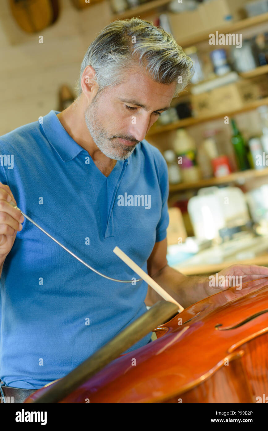 Closeup of craftsman making musical instrument bridge Stock Photo Alamy
