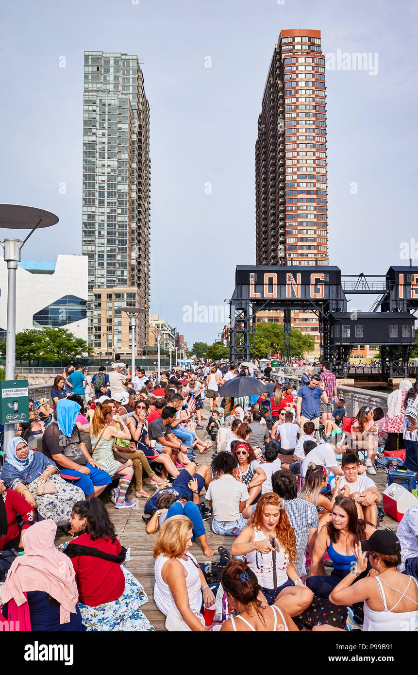 New York City, USA - July 4, 2018: People wait to watch Fourth of July Independence Day fireworks at a Long Island pier. Stock Photo