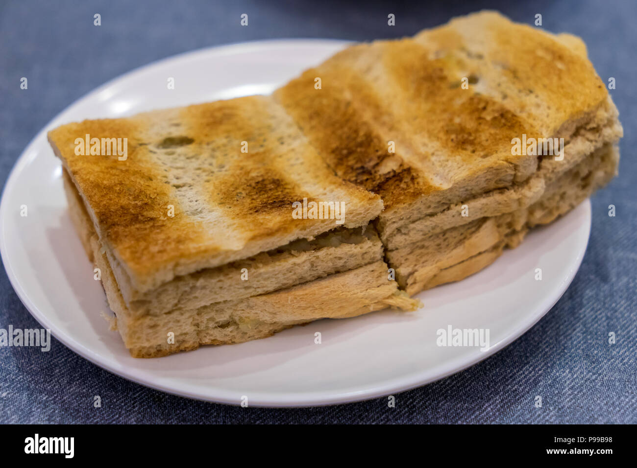 Traditional Singapore Breakfast called Kaya Toast, Bread with Coconut Jam and butter, Selective Focus technique Stock Photo
