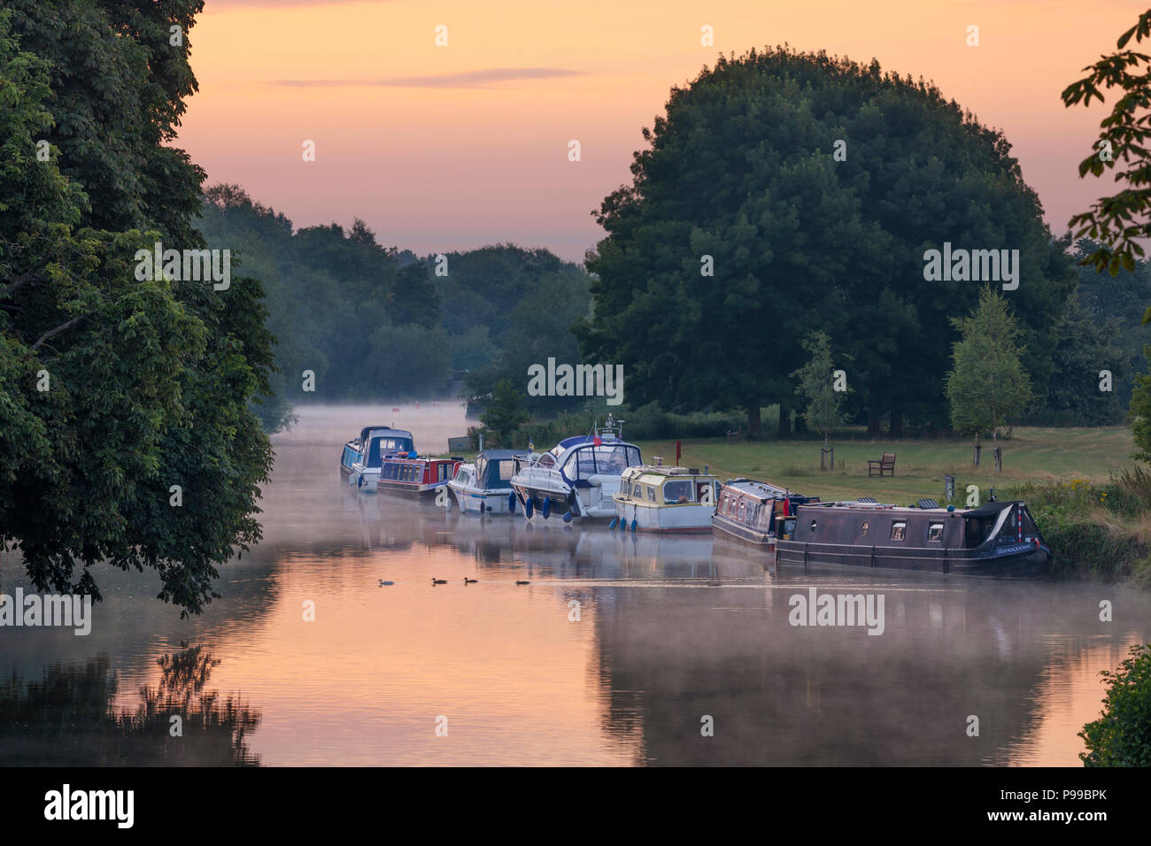 Boats moored on riverbank of the River Thames in dawn mist, Abingdon-on-Thames, Oxfordshire, England, United Kingdom, Europe Stock Photo