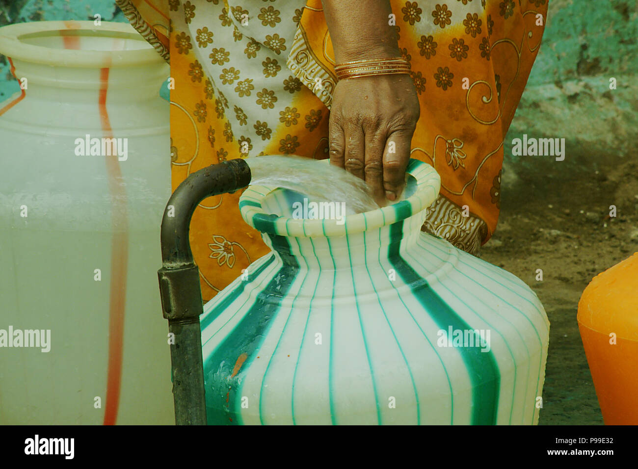 An Indian women carrying water in plastic pots, Plastic pots Stock Photo