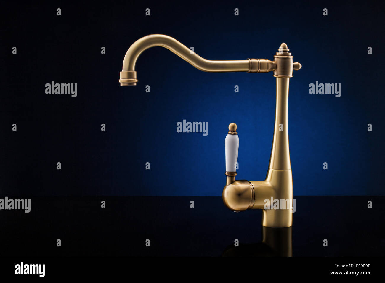 Modern kitchen faucet against dark blue background Stock Photo Alamy