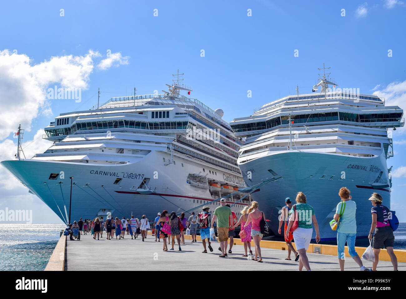 Grand Turk, Turks and Caicos Islands - April 03 2014: Passengers returning to the Carnival Liberty and Carnival Victory Cruise Ships docked side by si Stock Photo