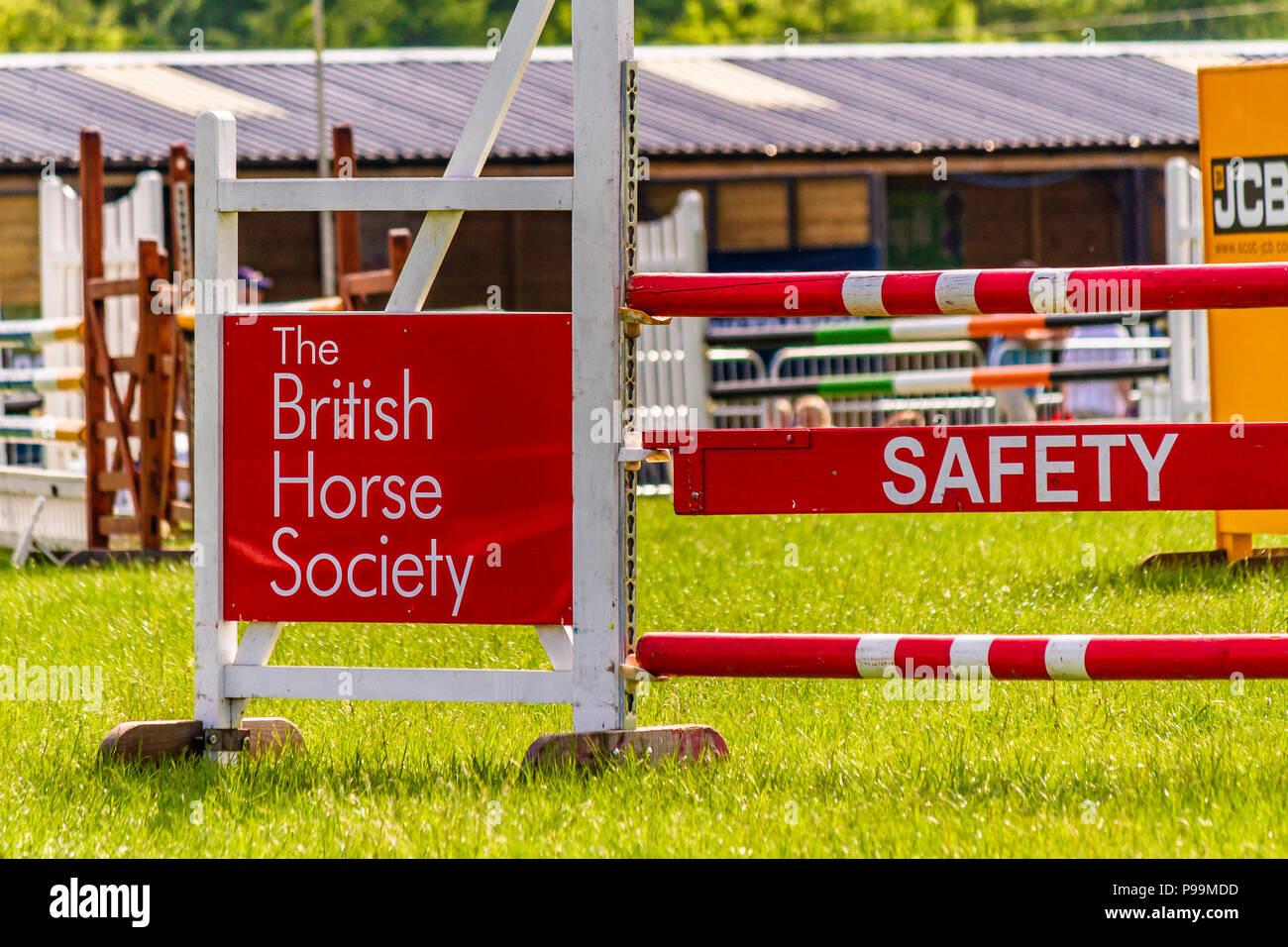 Show jump with British Horse Society banner and safety warning, UK. Stock Photo