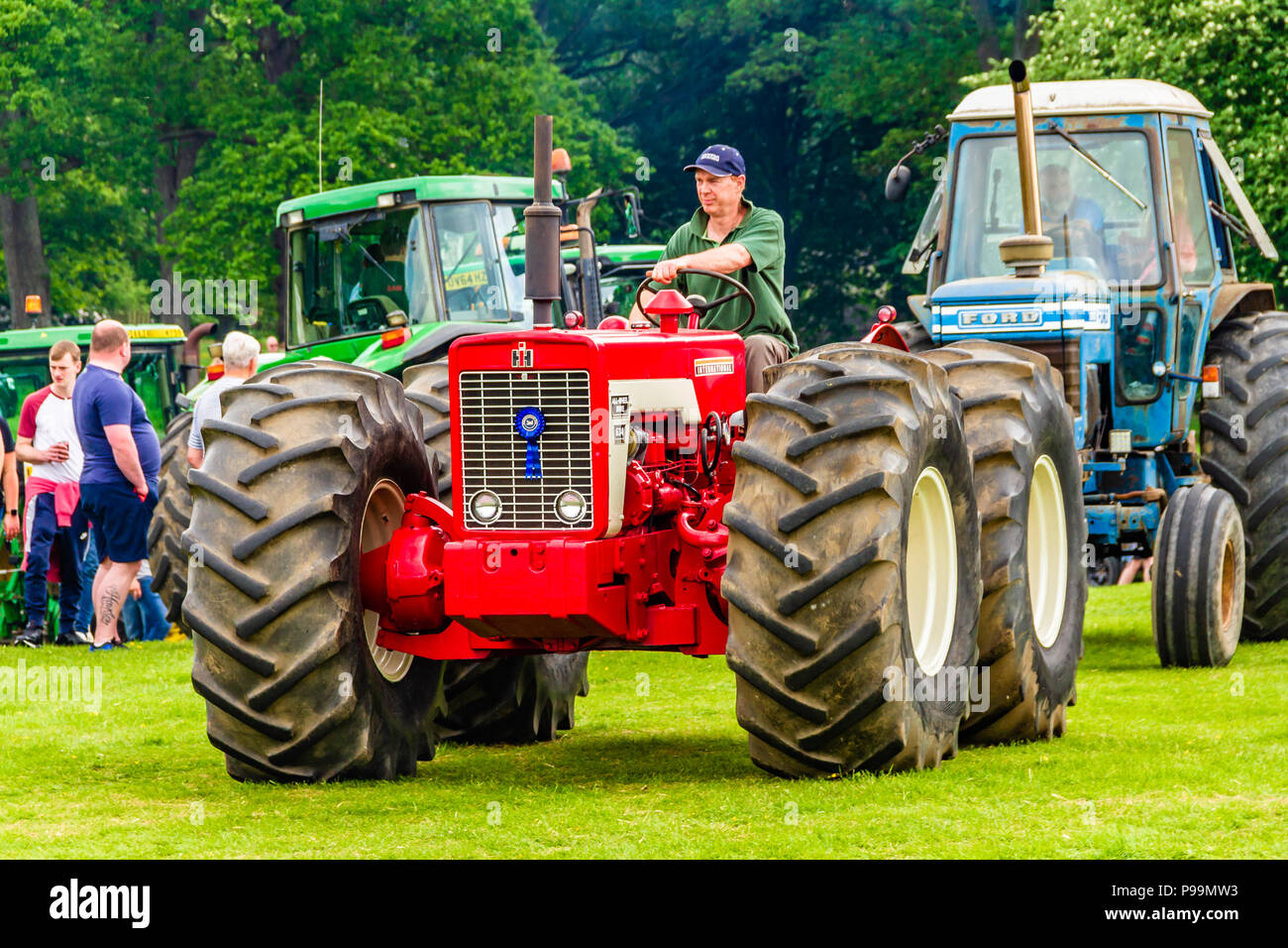 Man driving a prize-winning red tractor during a heritage tractor rally at Northumberland County Show, May 2018. Stock Photo