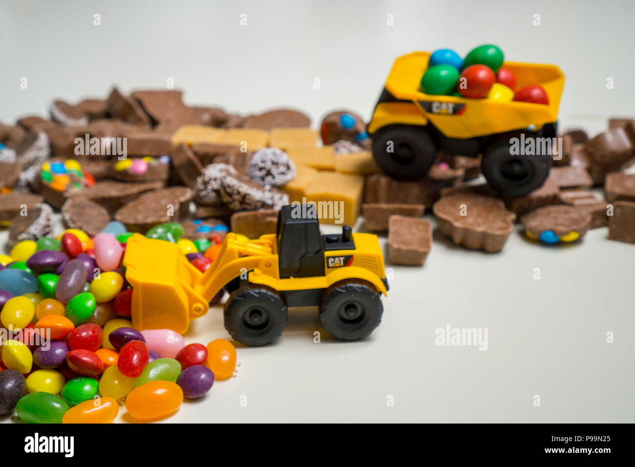 Toy dump trucks moving chocolate and candy around Stock Photo Alamy