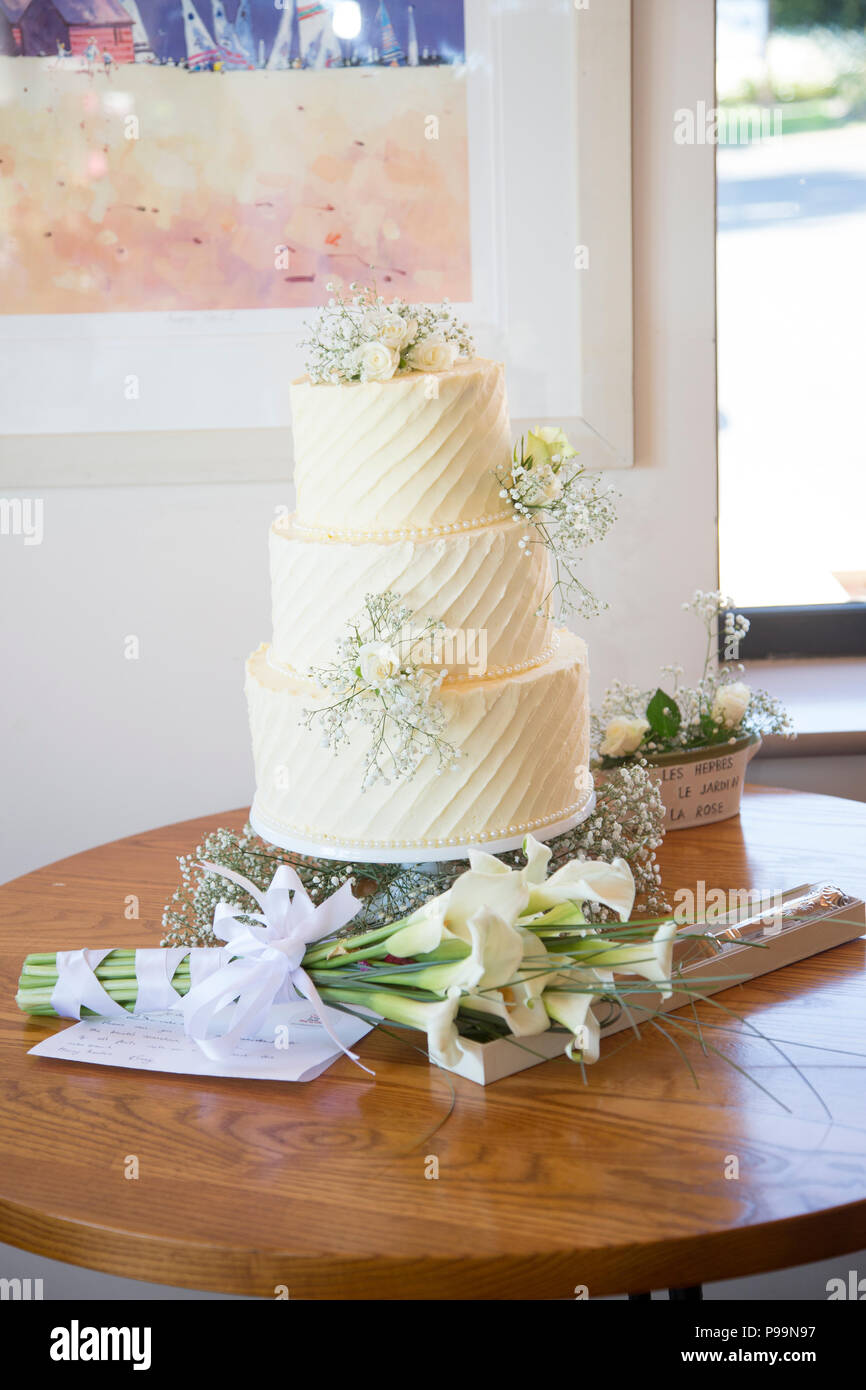 Wedding cake covered in cream butter icing decorated with real flowers