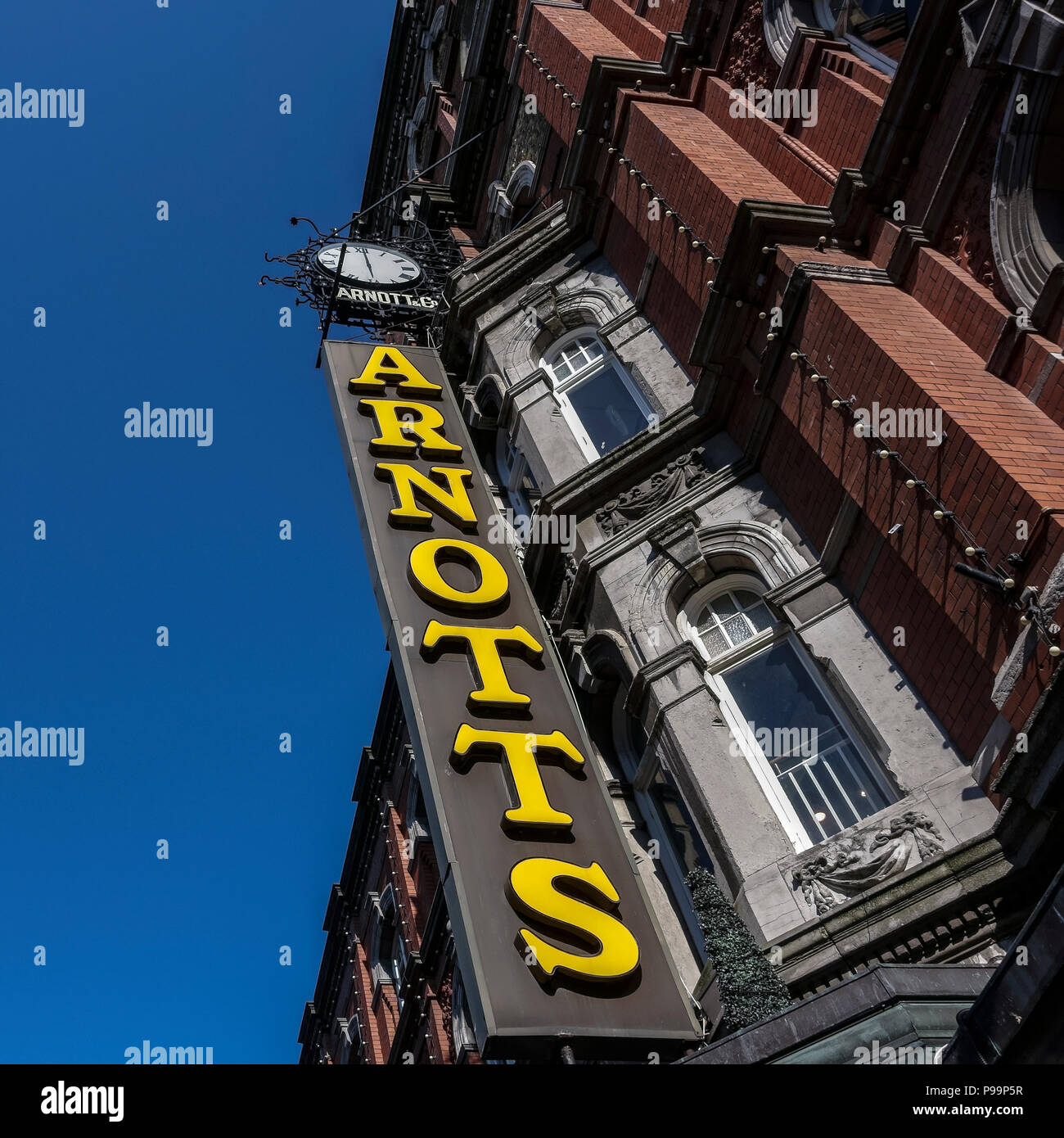 Shopping,Arnotts Department Store sign, brownstone building facade, Henry Street, Dublin, Ireland, Europe. Clear blue sky, copy space, low angle view. Stock Photo