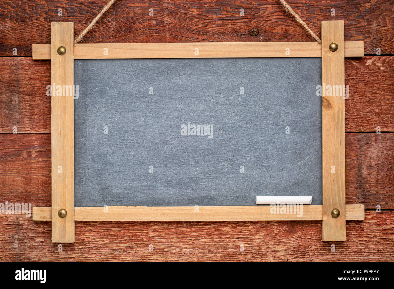 blank slate blackboard hanging on a rustic barn wood wall painted red Stock Photo Alamy