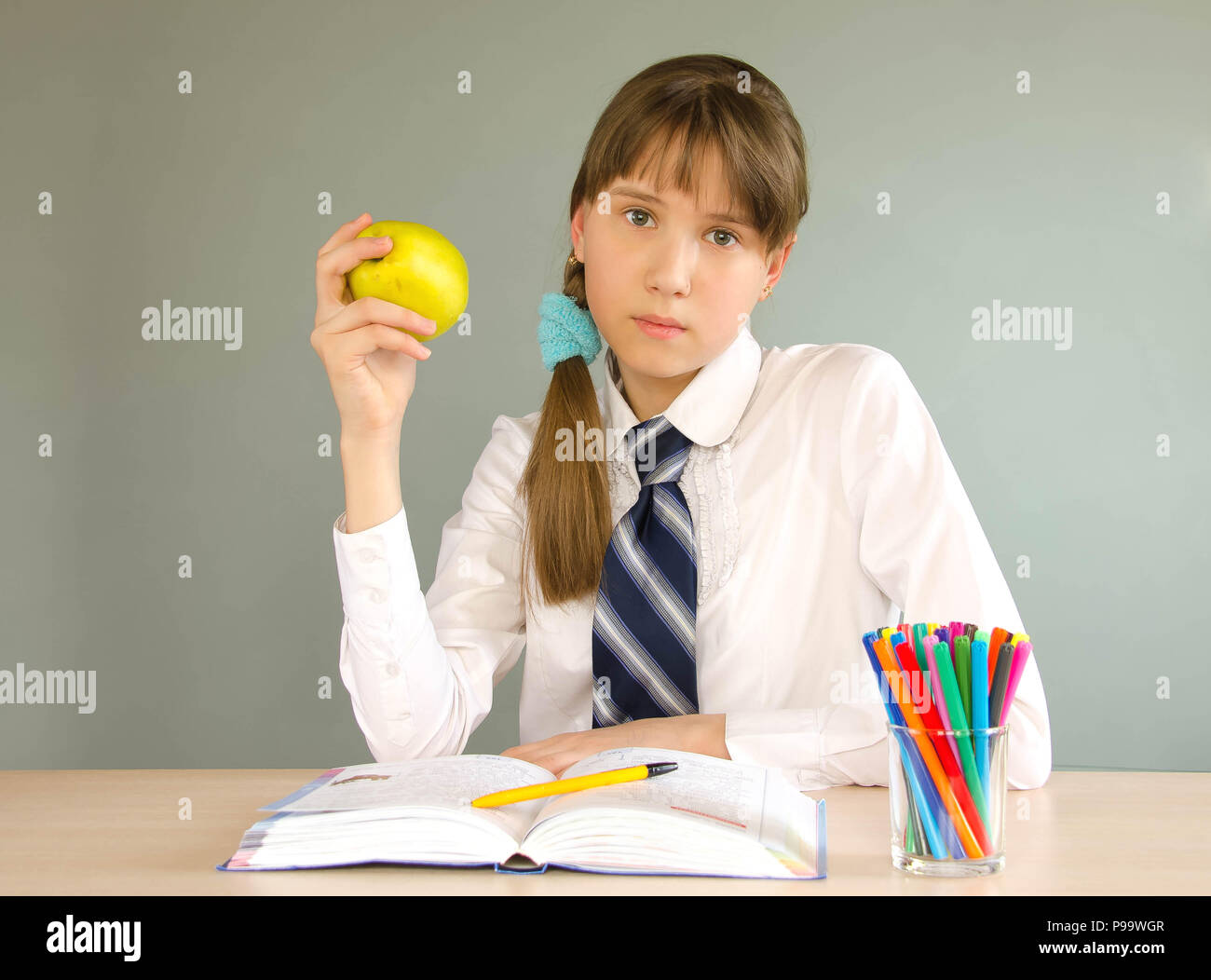 A schoolgirl girl sits at a school desk Stock Photo - Alamy