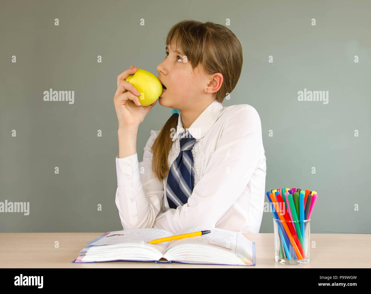 A schoolgirl girl sits at a school desk Stock Photo - Alamy